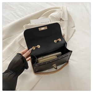 Detailed interior view showing a black floral shoulder bag with chain and phone compartment