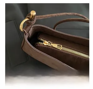 Détail du zip en métal doré lisse et texture de sac à bandoulière en daim marron