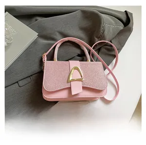 Sac bandoulière rose à paillettes, boucle dorée et smartphone pour comparaison de taille