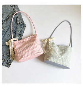 Detail of gingham shoulder bag with floral print and lace bow on white background