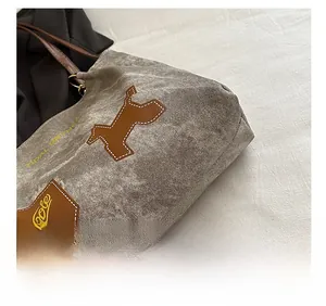 Détail montrant la texture en toile avec un écusson de chiot en cuir brun et coutures précises