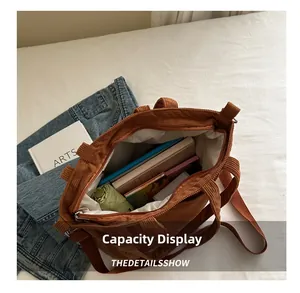 Spacious interior of brown corduroy tote bag showing books and a folding umbrella