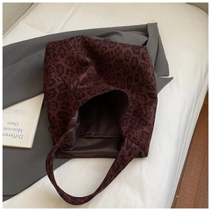 Detail shot of vintage leopard print tote bag on white linen with a gray blazer