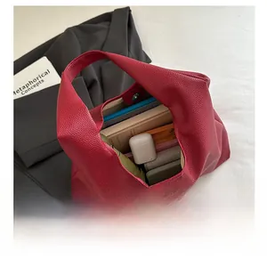 Interior view of red lychee leather tote bag showing large storage capacity for daily items