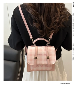 Rear view of model wearing pink plaid mini backpack with bear graphic and leather straps