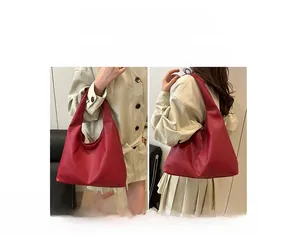 Detail of red minimalist tote bag showing versatile shoulder and hand-held carry options