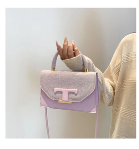 Detail of glitter flap texture and pink leather body with metallic T-shaped logo