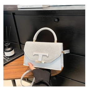 Detail shot of silver handbag with sequins, leather T-buckle and elegant handle