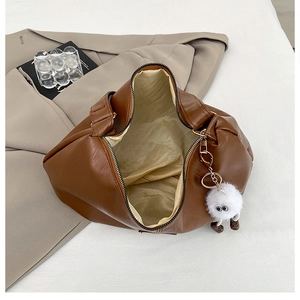 Brown PU leather tote bag interior view with beige lining and plush monster charm detail