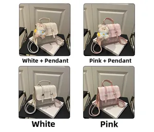 Detail view of small plaid crossbody bags in white and pink with cute bear charms