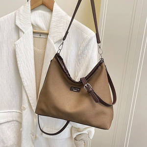 Minimalist canvas bucket bag with brown leather trim and adjustable crossbody strap