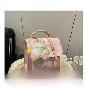 Detail of pink plaid backpack featuring cartoon illustration and plush bear keychain
