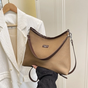 Minimalist canvas bucket bag with brown leather trim shown in a stylish lifestyle setting