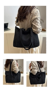Detailed view of black corduroy tote bag showing textured fabric and adjustable strap