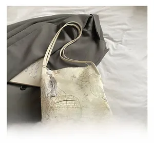 Detail of embroidered landscape shoulder bag with silk tassel on satin fabric