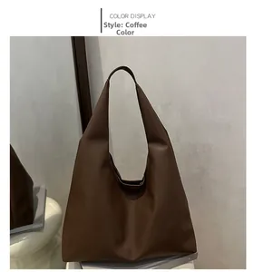 Detail of coffee brown tote bag featuring textured lychee grain faux leather finish