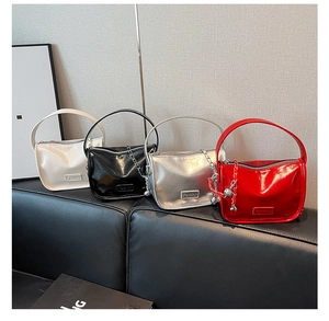 Détail de quatre sacs à main en cuir verni brillant en rouge, noir, argent et blanc