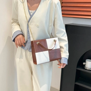 Sac bandoulière carré minimaliste avec bloc de couleurs marron et chaîne dorée sur mannequin