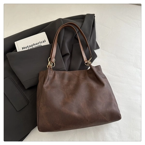 Détail du sac cabas en faux suède marron avec fines bandoulières et anneaux dorés