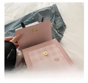 Detail showing high-quality metal magnetic clasp and pink plaid pocket of the mini bag