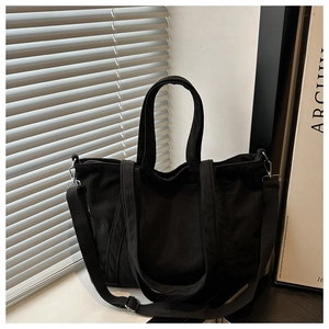 Detail of black corduroy tote bag showing metal D-ring and adjustable shoulder strap