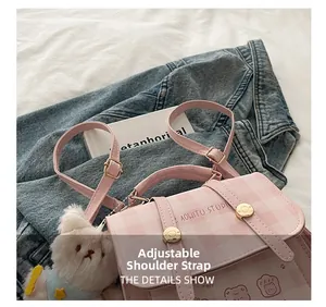 Detail of pink plaid shoulder bag with adjustable strap and plush bear keychain