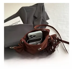 Détail de la capacité intérieure d'un sac à franges en daim marron avec téléphone et cartes