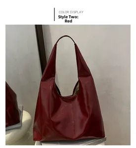 Detail of a large glossy red patent leather tote bag on a prop book in a room