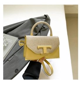 Detail of yellow crossbody bag with woven texture, T-shaped gold buckle, and top handle