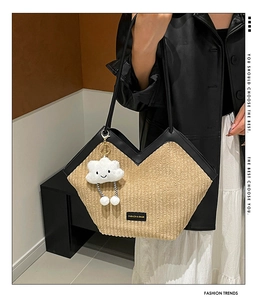 Close-up of beige striped corduroy tote with black faux leather trim and cloud charm