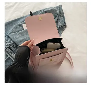 Detailed interior view of a pink crossbody bag showing capacity for a phone and wallet