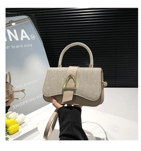 Détail d'un sac à main bicolore avec sequins brillants et boucle dorée en forme de D