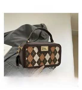 Close-up of retro plaid crossbody bag with wide woven strap and gold metal hardware