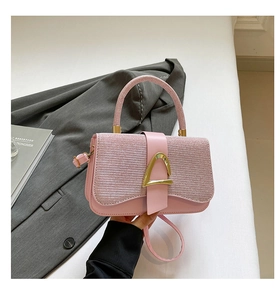 Détail du sac à bandoulière rose avec rabat pailleté et boucle métallique dorée chic