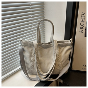 Close-up of light gray corduroy tote bag texture with adjustable wide shoulder strap