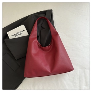 Dettaglio della pelle martellata bordeaux e della tracolla ampia della borsa hobo chic