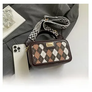 Detail of argyle pattern camera bag with striped strap and smartphone size comparison