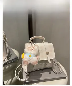 Detail of white mini backpack with yellow plaid pattern and cute plush bear charm