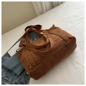 Detail of caramel corduroy tote bag showing vertical ribbed texture and brown woven strap