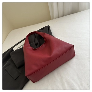 Dettaglio borsa hobo bordeaux con trama a grana litchi su tessuto bianco