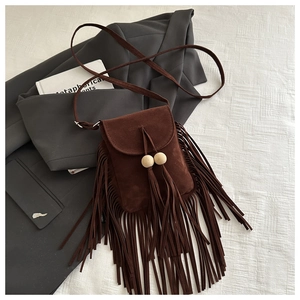 Détail du sac bandoulière vintage en daim marron avec de longues franges et perles