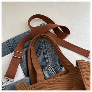 Detail of brown corduroy multi-functional bag with canvas strap and metal buckles
