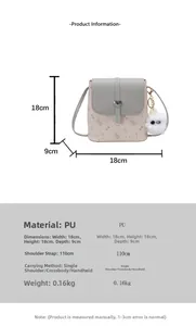 Detailed view of crossbody bag with cat print, heart clasp, and plush ball accessory