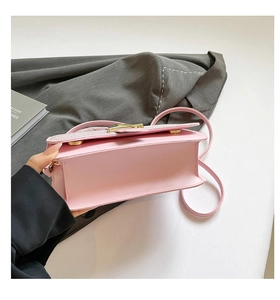 Vue détaillée du sac bandoulière en cuir rose montrant la base et la boucle dorée