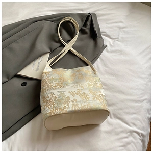 Detail of elegant oriental gold floral jacquard embroidery on cream tote bag