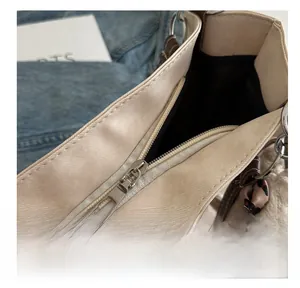 Detailed close-up of smooth metal zipper and leopard print bow charm on canvas tote bag