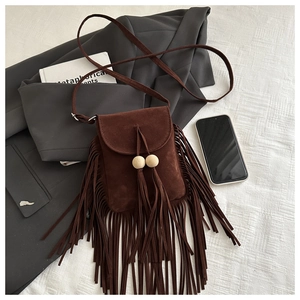 Détail du sac à franges en daim marron avec perles en bois et longues franges