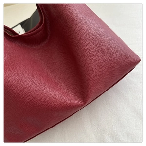 Dettaglio ravvicinato della pelle martellata rosso scuro di una morbida borsa tote