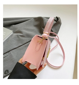 Vue détaillée du sac à main en cuir rose clair avec texture fine et boucle dorée