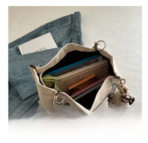 Interior view showing large capacity of beige canvas tote with books and tablet